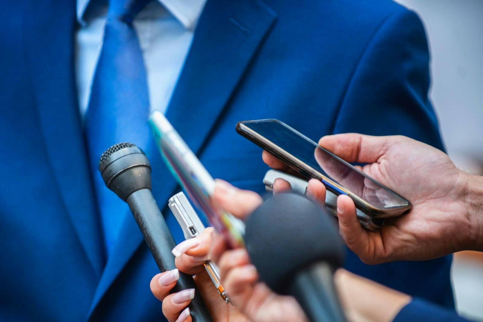 close up view of several reporters hands holding microphones and cellphones
